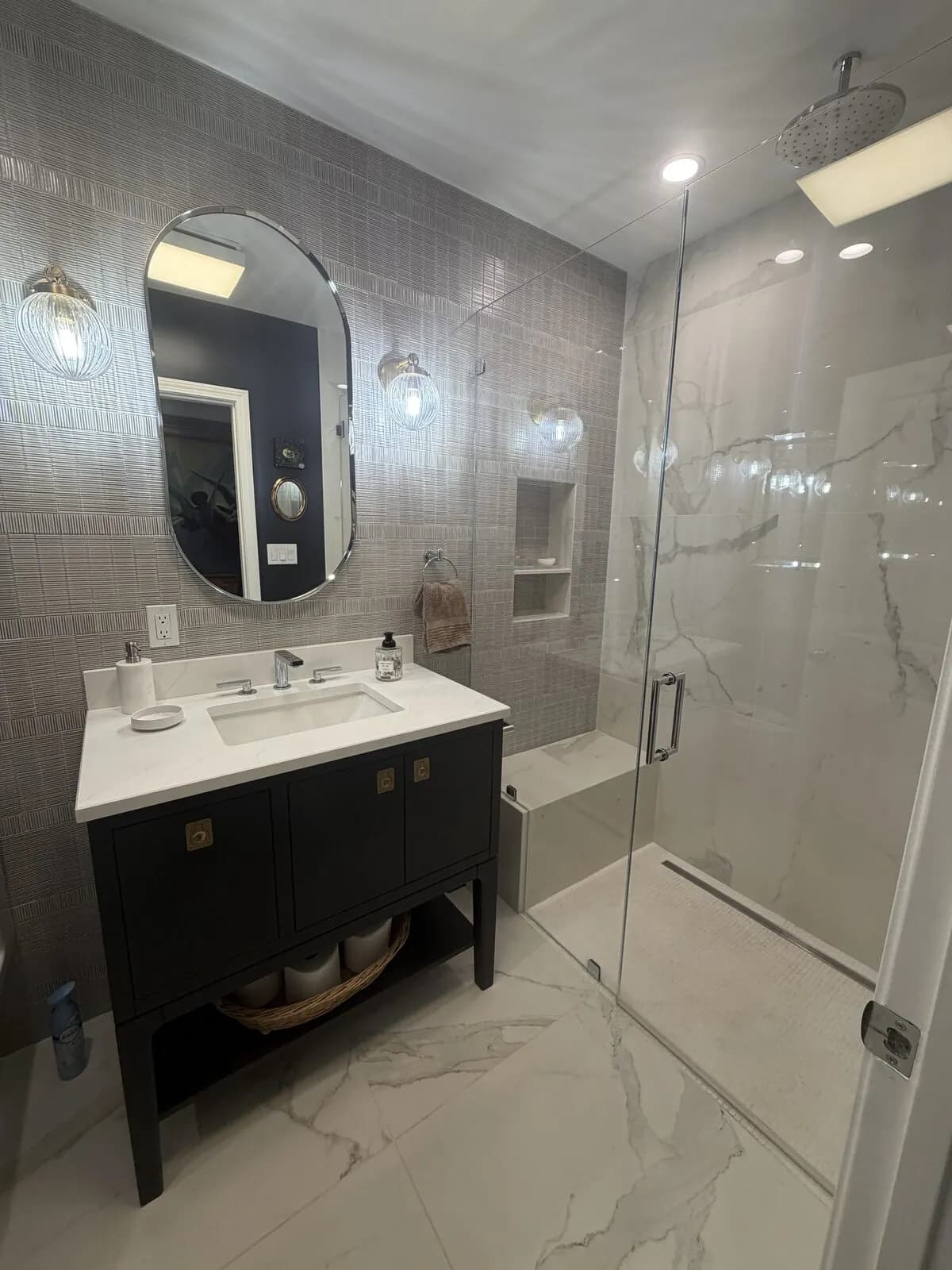 Finished bathroom remodel with walk-in glass shower, vanity sink, and chrome fixtures