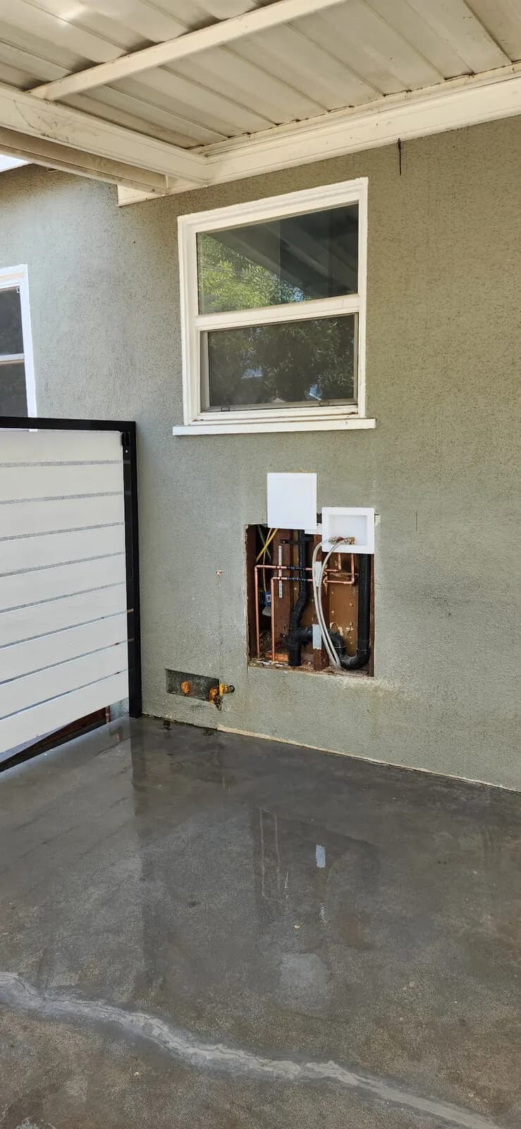 Laundry rough-in with copper supply, ABS drain, and washing-machine outlet box in an exterior stucco wall