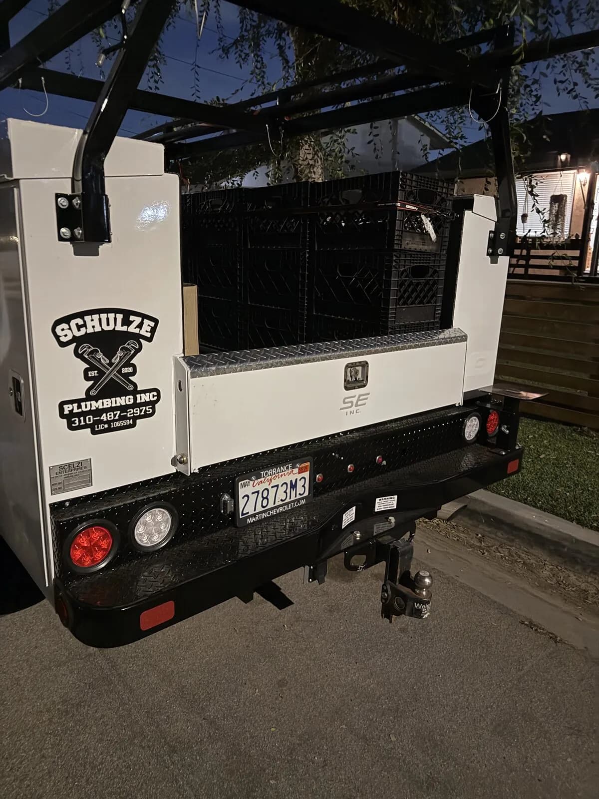 Rear of a Schulze Plumbing Inc. service truck showing crossed-wrench logo, phone, and license number